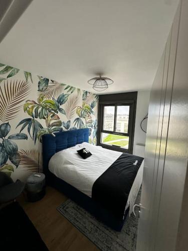 - une chambre avec un lit dans une pièce ornée de plantes dans l'établissement Le National panoramique, à Tours