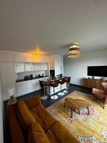 un salon avec un canapé et une table et une cuisine dans l'établissement Le National panoramique, à Tours