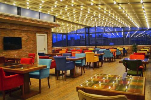 GRAND DELUX HOTEL في سامسون: مطعم يحتوي على كراسي وطاولات ملونة وطاولة