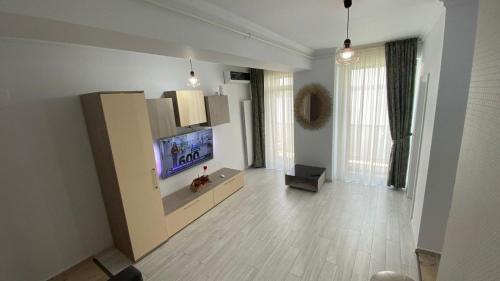sala de estar con TV de pantalla plana en la pared en ELEGANCE APARTMENT, en Marina di Monasterace