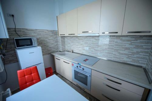 una pequeña cocina con armarios blancos y microondas en ELEGANCE APARTMENT, en Marina di Monasterace