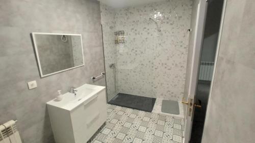 a white bathroom with a sink and a shower at Casa turística Poncehouse in Tomelloso