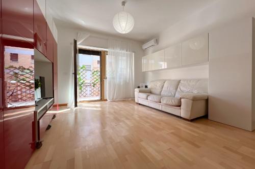 La Casa di Roma في روما: غرفة معيشة بها أريكة بيضاء وتلفزيون
