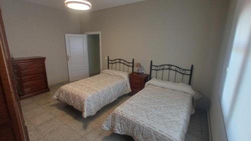 a bedroom with two beds and a lamp in it at Casa turística Poncehouse in Tomelloso