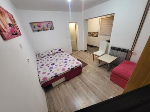 a small room with a bed and a chair at Apartman u centru Prnjavor in Prnjavor