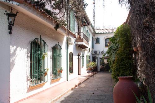 an alley with a large vase on the side of a building at Hotel Boutique La Candela in Salta