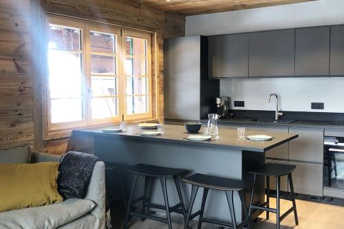 een keuken met een aanrecht en krukken in een kamer bij Bianca appartement proche centre in Megève