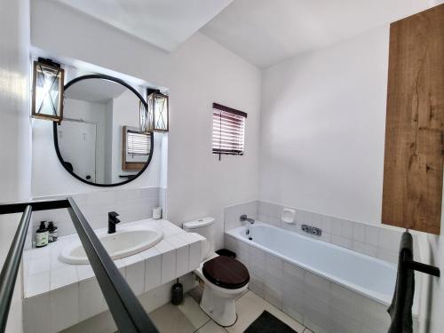 a bathroom with a sink and a toilet and a mirror at Oceanfront Greek Style Gem in Ballito