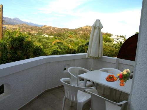 a balcony with a table and chairs and a view at Kastro Studios Apartments in Myrtos