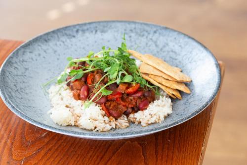 a bowl of rice with meat and vegetables and chips at The Valley Hotel, Anglesey in Valley