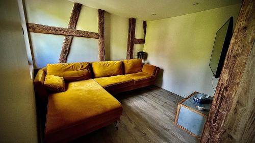 凱澤貝爾的住宿－La jolie maison bleue avec terrasse，客厅配有黄色的沙发和桌子