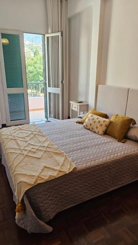 - une chambre avec un grand lit et une grande fenêtre dans l'établissement Garden and Seaview Apartment - Free Parking, à Funchal