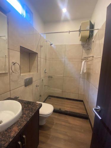 un bagno con doccia, WC e lavandino di Hotel Cedar a Jaipur