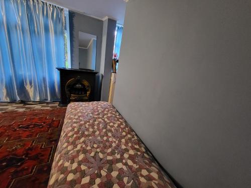 a bedroom with a bed in a room with a fireplace at Gabala Garden hostel in Gabala