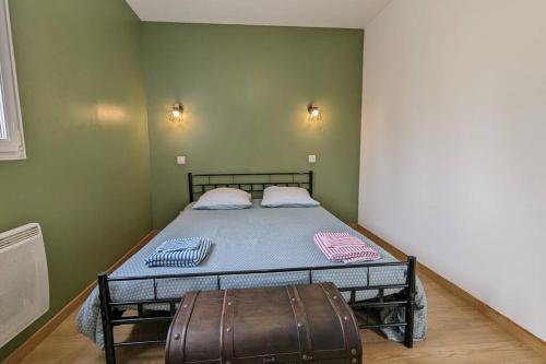 a bedroom with a bed with a suitcase next to it at Gîte maison à Montendre in Montendre