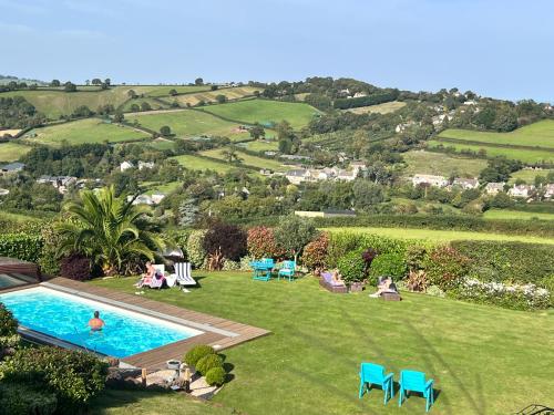 uma imagem de um jardim com piscina em Halekulani Devon Homestay em Torquay