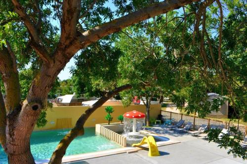 una piscina con tumbonas y un árbol en Domaine de la Palme, en Lapalme