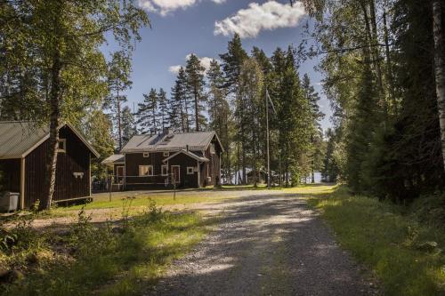 a dirt road next to a house and trees at Uniikki lomapaikka in Jämsä