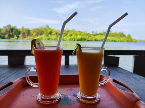 twee drankjes in mokken op een dienblad bij Lake Lane Guest Rest in Koggala