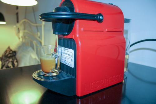 a red coffee maker with a glass on a table at Oikies Art Rooms in Ángistron