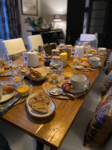 une table en bois avec des assiettes de nourriture et de boissons dans l'établissement Villa Maskali, à Cuxac-dʼAude