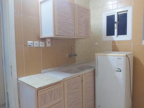 uma pequena cozinha com um lavatório e um frigorífico em اجنحة ارمادا em Al Qunfudhah