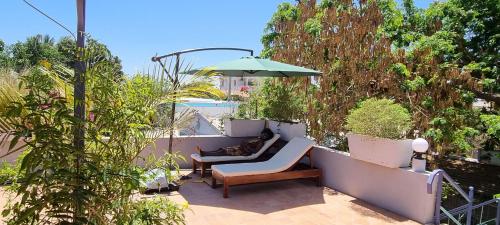 a patio with two chairs and an umbrella at Flamingo résidence in Toliara