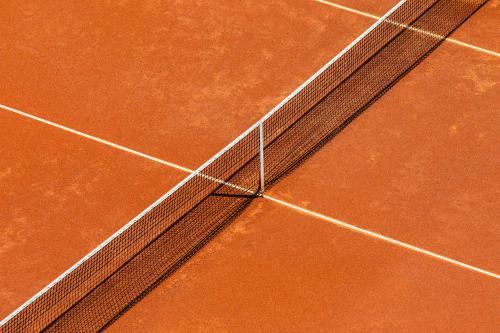 una red en una pista de tenis en Boutique-Hotel Ballguthof am Golfplatz en Lana