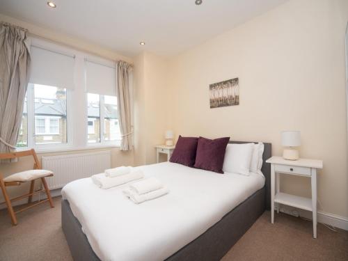 Un dormitorio con una gran cama blanca y una ventana en Pass the Keys Cozy Hidden Gem 2Br Near Station Shops, en Londres