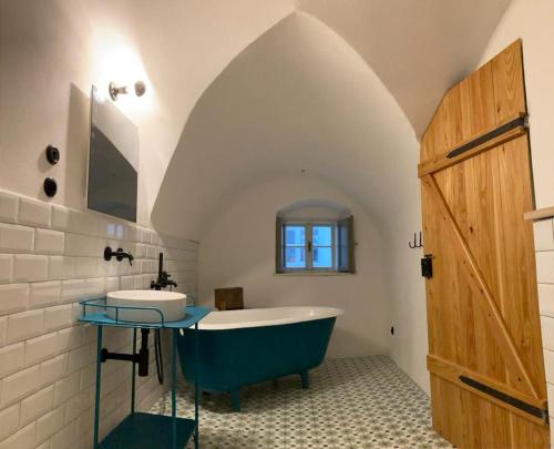 a bathroom with a blue tub and a sink at Am Znaimertor in Retz