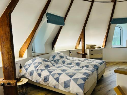 a bedroom with a bed in the attic at Chambres Vaugoubert in Saint-Germain-de-Varreville