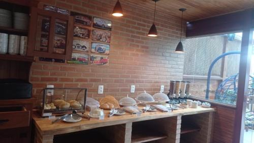a table with a bunch of different types of bread at Pousada Renovo da Serra in São Pedro da Serra
