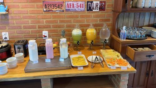 a table with bottles of juice and food on it at Pousada Renovo da Serra in São Pedro da Serra
