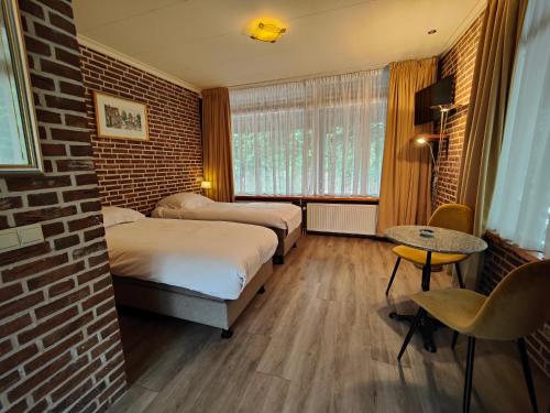 a room with two beds and a brick wall at Buitengoed de Panoven in Zevenaar