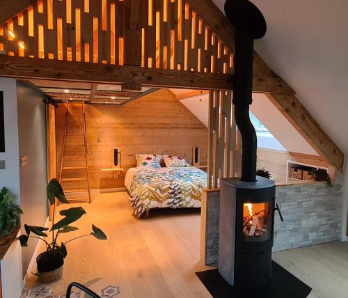 1 dormitorio con estufa de leña en una habitación en Gîte des Vernet - Loft chaleureux entre lacs et montagnes, 