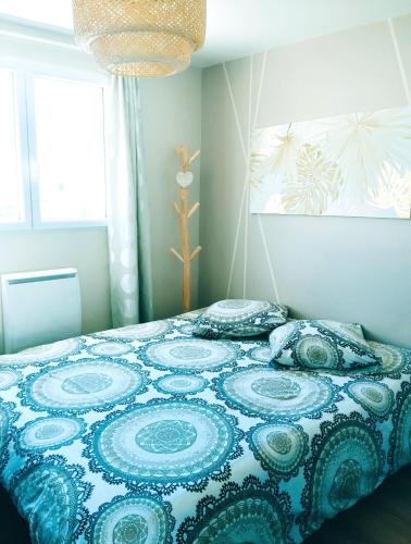 une chambre avec un lit avec une couette bleue et blanche dans l'établissement Le 
