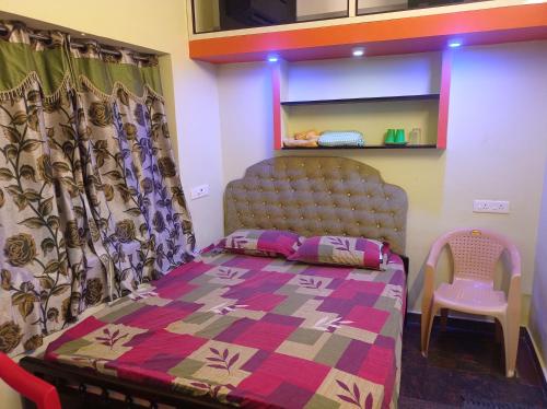 a small bedroom with a bed and a chair at Siddharth villa in Puducherry