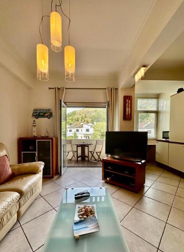 a living room with a couch and a tv at Atlantic Bay in Costa da Caparica
