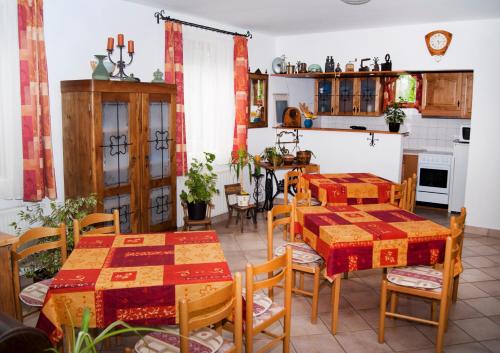 a kitchen and dining room with tables and chairs at Varga Apartmanház in Zalakaros
