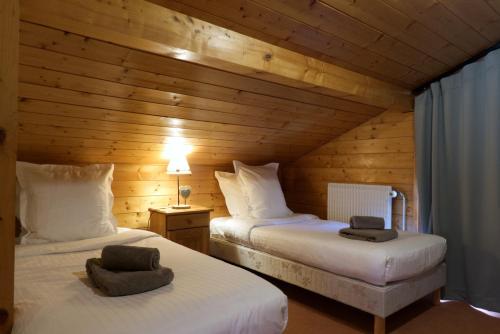 レ・ジェにあるChalet Portes du Soleil 2のベッド2台 木製の壁の部屋