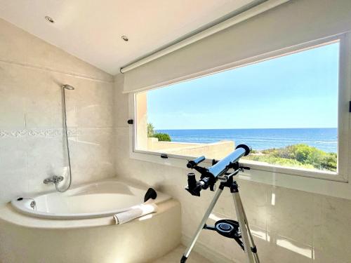 L'Ametlla de MarにあるVilla Catalina Stunning 4bedroom villa with air conditioning sea views & private swimming pool ideal for familiesのカメラ付きのバスルーム(バスタブ付)、窓が備わります。