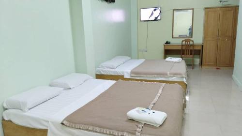 un grupo de 3 camas en una habitación en SUSAN HOTEL SEAFRONT, en Sandakan