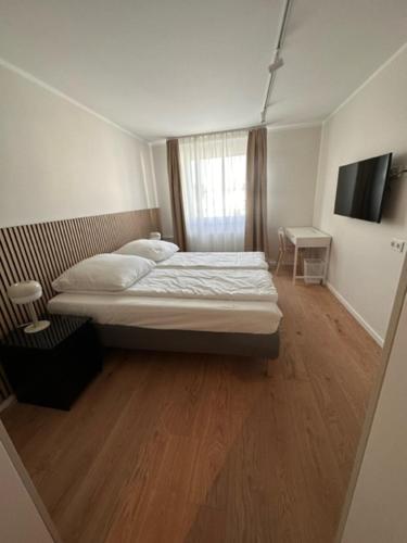a small bedroom with a bed and a window at ELBI Apartment in Frankfurt/Main