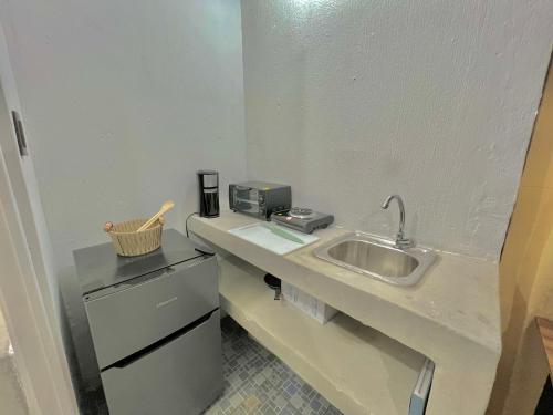 een kleine keuken met een spoelbak en een apparaat bij Citadin Yurrita in Guatemala