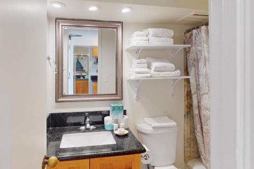 a bathroom with a sink and a toilet and a mirror at Island Colony 4218 in Honolulu