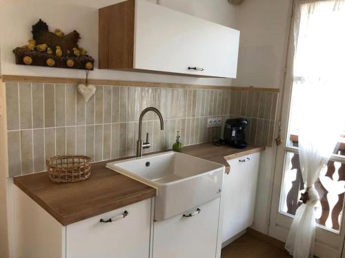 a kitchen with a white sink and a window at LE COEUR DE GERARDMER F2 PLEIN CENTRE 4P + GARAGE in Gérardmer