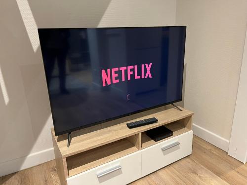 a flat screen tv sitting on a tv stand at Le Caladois in Villefranche-sur-Saône