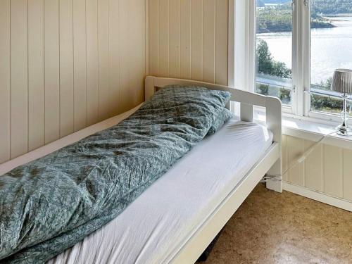 Bett in einem Zimmer mit Fenster in der Unterkunft Holiday home Snillfjord II in Snillfjord