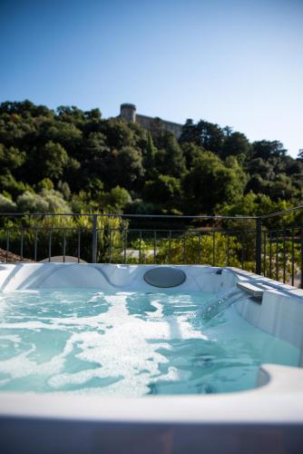 a jacuzzi tub with a hill in the background at Vigna Caio Relais & Spa in Bracciano