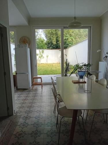 een keuken met een witte tafel en stoelen en een koelkast bij Spacieux Appartement 1 chambre double & jardin in Brussel